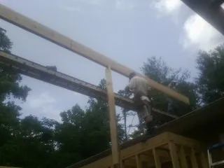 Carpenter setting a ridge beam over a new addition frame — Ice Dam Removal by Roofing Brothers in Richburg