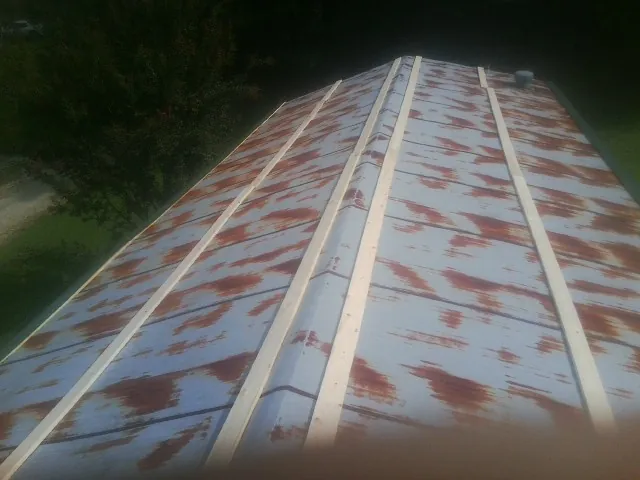Rusted metal roof panels with new wood purlins before replacement — Storm Damage Roof Repair in Richburg by Roofing Brothers