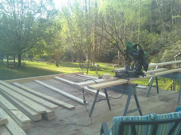 Miter saw and framing lumber on a deck under construction in Richburg