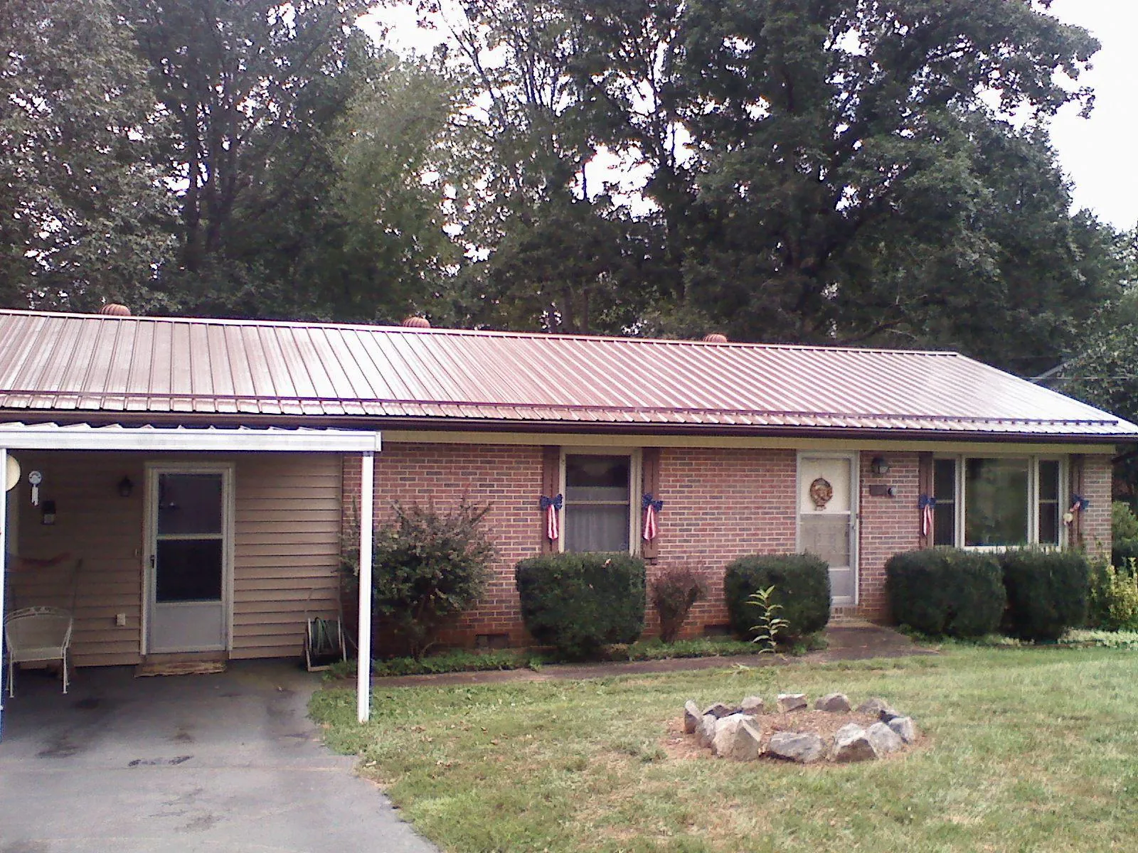 Bronze metal roof and carport on a brick ranch home — Roof Repair work by our crew in Richburg